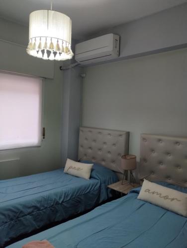 a room with two beds and a air conditioner at Departamento céntrico muñecas in San Miguel de Tucumán