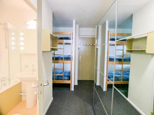 Cette petite chambre comprend des lits superposés et une salle de bains. dans l'établissement Résidence Plein Soleil - Studio lumineux avec balcon · Skis aux pieds MAE-7474, à Tignes