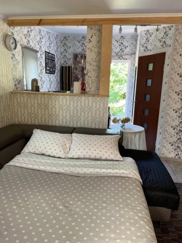a bedroom with a large bed with white sheets at Atpūtas vieta ar pirti, with wi-fi, self check in and private parking in Ventspils