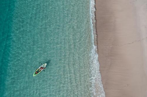 an overhead view of a boat in the water next to a beach at Boungainvillea 7105 Luxury Apartment - Reserva Conchal in Playa Conchal