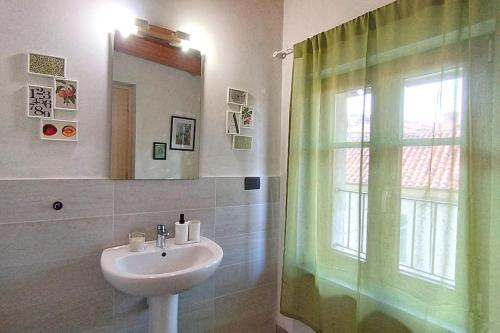 a bathroom with a sink and a shower curtain at Centro Storico - Casa con Wifi e Parcheggio a 100m in Saluzzo