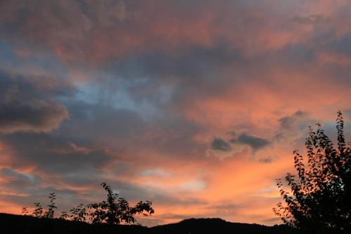 a cloudy sky at sunset with trees in the foreground at Aktiv Hotel Karnia in Hermagor