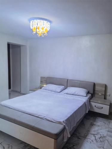 a bedroom with a bed and a chandelier at City Bleu Maroc in Tangier