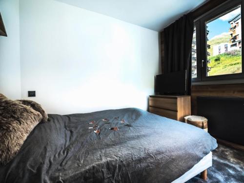 sypialnia z łóżkiem, telewizorem i oknem w obiekcie Résidence Rond Point Des Pistes B - Appartement rénové·Départ et retour ski aux pieds· MAE-2414 w mieście Tignes