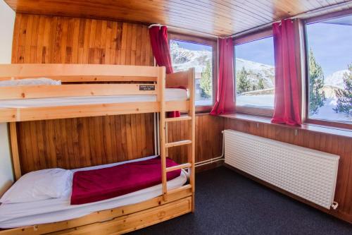 two bunk beds in a room with windows at Résidence Roches Rouges A - Appartement calme et près des pistes. MAE-2474 in Tignes
