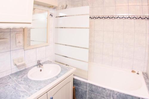 a white bathroom with a sink and a mirror at Résidence Roches Rouges A - Appartement calme et près des pistes. MAE-2474 in Tignes