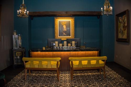 a bar in a blue room with two chairs at Hotel Boutique Naura Centro in Oaxaca City