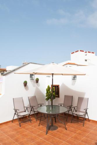 a table and chairs with an umbrella on a patio at Home2Book La Casita del Muelle in Garachico
