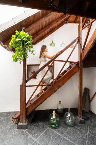 a woman in a white dress sitting on a shelf at Home2Book La Casita del Muelle in Garachico