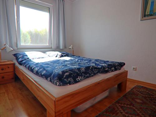a bed in a room with a window at Strandhaus an der Wohlenberger Wiek in Hohenkirchen