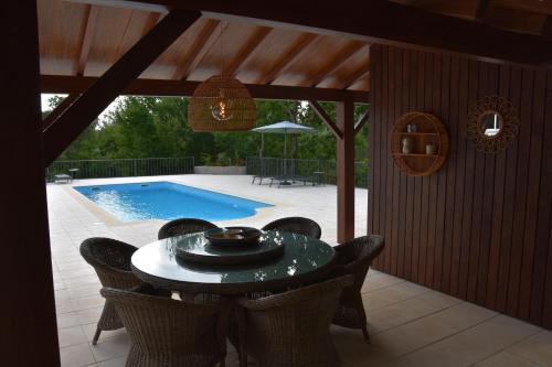 a patio with a table and chairs next to a pool at Casa Toupeira in Folques