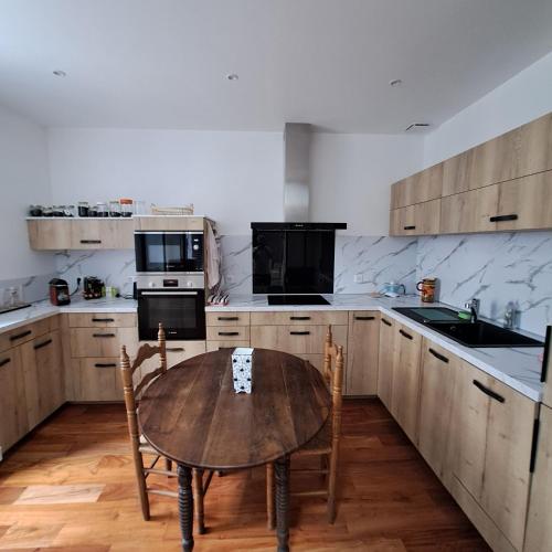 une cuisine avec une table en bois et une table et des chaises dans l'établissement StGosweet, à Saint-Gaudens