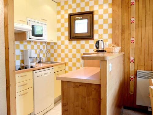 - une cuisine avec du papier peint à damier jaune et blanc dans l'établissement Résidence Soldanelles - Appartement rénové·Proche des pistes·Balcon MAE-0714, à Tignes