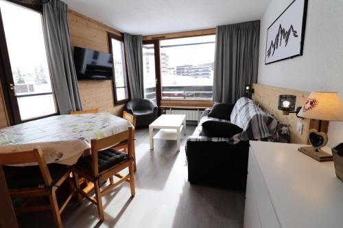 un salon avec une table et un canapé dans l'établissement Résidence Soldanelles - Appartement rénové·Proche des pistes·Balcon MAE-0714, à Tignes