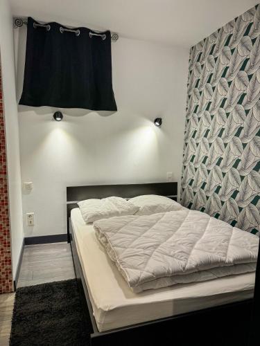 une chambre avec un grand lit avec une tête de lit dans l'établissement Appartement T1 Bis - Haute-Ville, à Auch