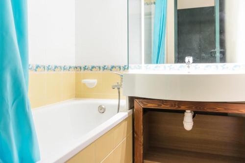 une salle de bain avec une baignoire, un lavabo et un miroir dans l'établissement Résidence Mont Soleil A - Appartement 5 personnes - Plagne Soleil MAE-0294, à Aime La Plagne