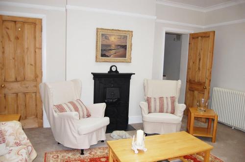 a living room with two chairs and a fireplace at 65A Beauchamp in Leamington Spa