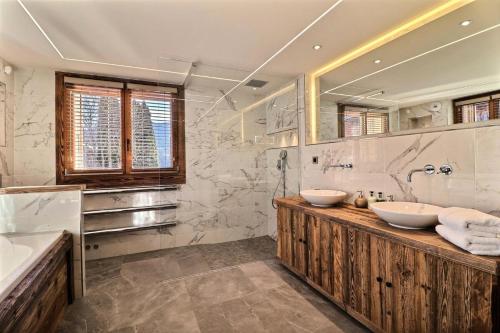 une salle de bain avec deux lavabos et un grand miroir dans l'établissement Résidence Soprano - Chalet Soprano - 12 Personnes - Montriond MAE-3861, à Montriond