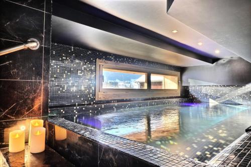 - une grande piscine dans une salle de bains revêtue de carrelage noir dans l'établissement Résidence Soprano - Chalet Soprano - 12 Personnes - Montriond MAE-3861, à Montriond