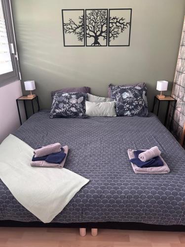 a bedroom with a bed with two towels on it at Le soleil levant plage , casino, thalasso in Bénodet