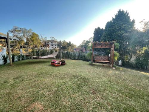 a yard with a hammock and a fence at Pousada Flor de Lua Monte Verde in Monte Verde