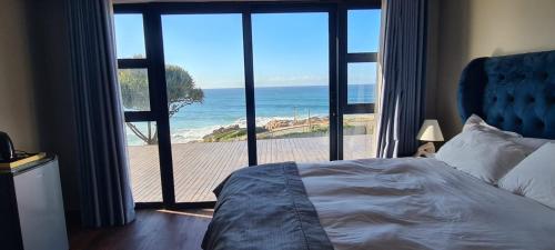 a bedroom with a bed and a view of the ocean at Beach House Margate in Margate