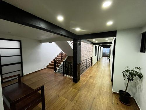 a living room with a staircase and a wooden floor at Hotel posada Juquila in Zacatlán