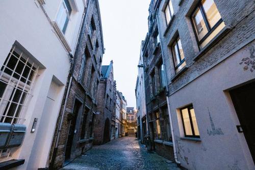 an empty alley in an old city with buildings at De Moriaan Historic Center in Antwerp