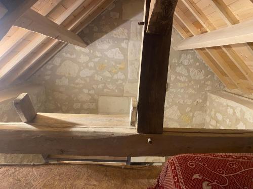 - un lit en bois dans une chambre avec un toit dans l'établissement Immersion dans une loge de vigne, à Ingrandes-de-Touraine
