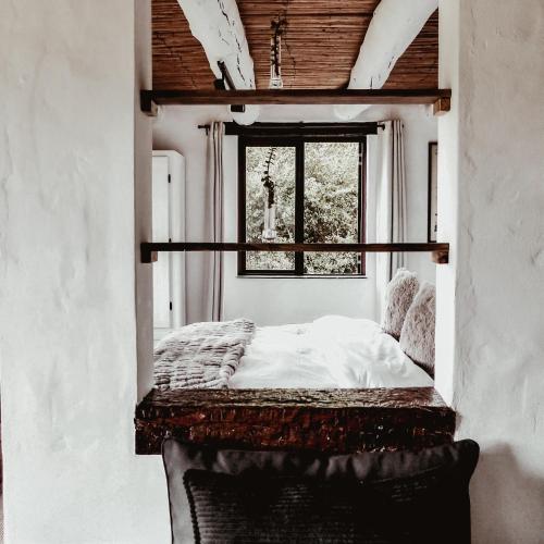 a bed in a room with a window at Stanley Island in Plettenberg Bay
