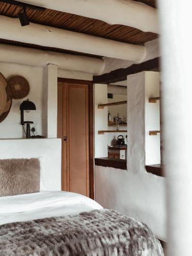 a bedroom with a bed and a wooden ceiling at Stanley Island in Plettenberg Bay