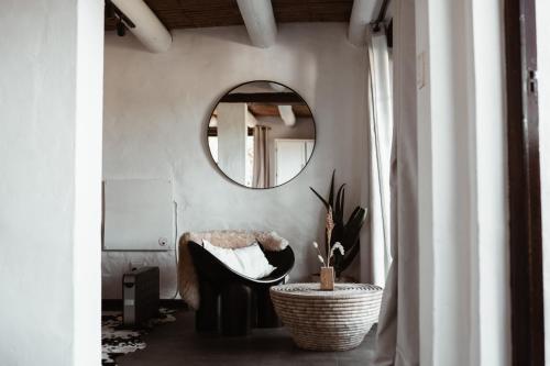 a bathroom with a mirror and a chair in a room at Stanley Island in Plettenberg Bay