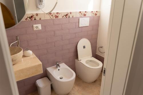 a small bathroom with a toilet and a sink at Zahra Superior Suite with private pool in Sannicola
