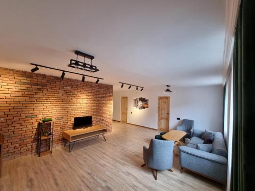 a living room with a couch and a brick wall at Villa Sunshine ,apartment with 4 bedrooms ,whole apartment, апартаменты целиком in Dilijan