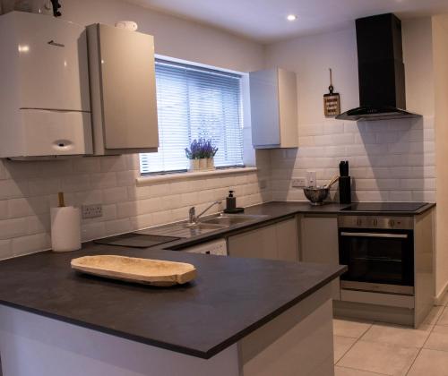 a kitchen with a counter top with a cutting board on it at Comfortable 3 bed house in central location, Stevenage in Stevenage