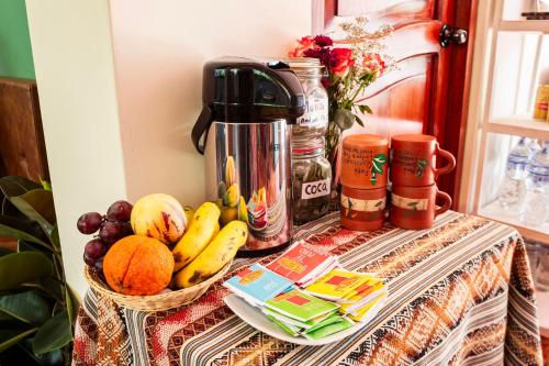 a table with a bowl of fruit and a coffee maker at PERU QUECHUA'S LODGE Riverside in Ollantaytambo