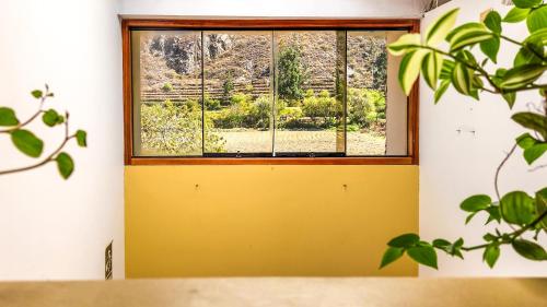 a room with a yellow door and a window at PERU QUECHUA'S LODGE Riverside in Ollantaytambo