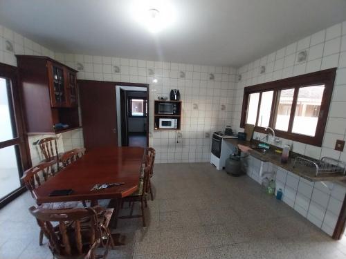 Una cocina con una mesa y sillas de madera en una habitación. en Casa Ampla 2 dormitorios LARANJAL temporada, en Pelotas