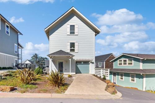 a white house with a driveway in a neighborhood at Driftaway Dreamer in Lincoln City