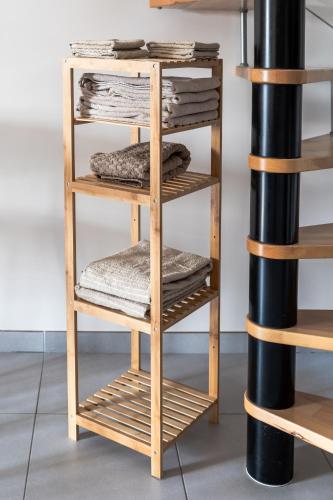 - un porte-serviettes en bois avec des serviettes pliées dans l'établissement Appartement F2 proche Disneyland, à Chaumes-en-Brie