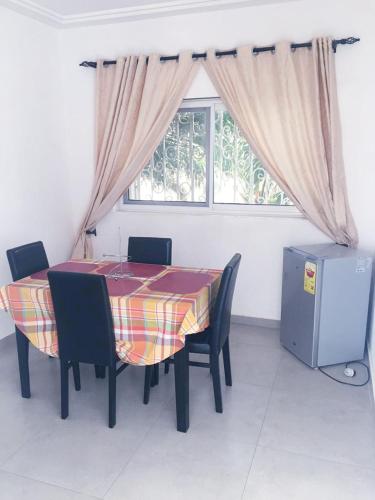 a dining room with a table and chairs and a window at Residence NANEVIE in Adido Gomé