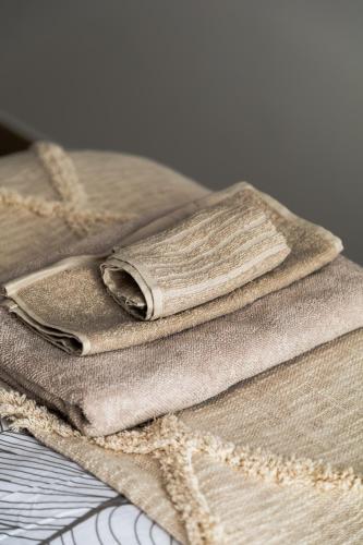 une pile de serviettes posée sur un lit dans l'établissement Appartement F1 proche de Disney, à Chaumes-en-Brie