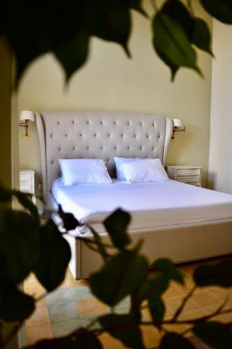 a bed with white sheets and pillows in a bedroom at Grand Arcanum Apartment 2 - Comfortable and Elegant in Senglea
