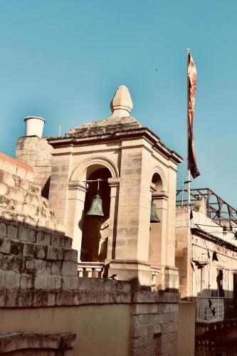 a building with a bell tower on top of it at Grand Arcanum Apartment 2 - Comfortable and Elegant in Senglea