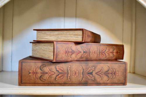 four books stacked on top of each other on a shelf at Grand Arcanum Apartment 2 - Comfortable and Elegant in Senglea