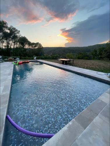 une piscine avec un coucher de soleil en arrière-plan dans l'établissement Villa piscine, à Roquefort-les-Pins