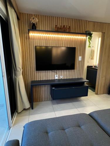 a living room with a flat screen tv on a wall at Studio 1304 Estilo e bem-estar no Cariri in Juazeiro do Norte