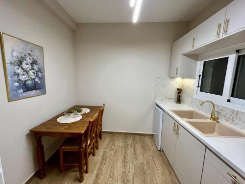 a small kitchen with a table and a sink at Emerald Luxury Apartments - ATH Airport in Spáta