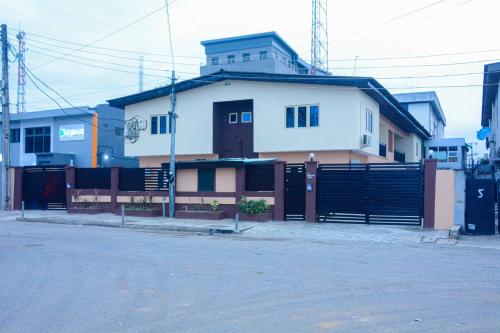 a house with a fence in front of a building at Rubys Apartment in Eregun