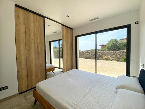 une chambre avec un lit et une grande fenêtre dans l'établissement Villa moderne piscine privative hauteurs de Nimes, à Nîmes